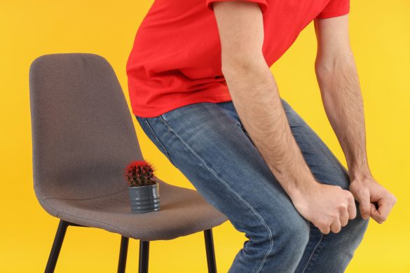 man sit down chair with cactus hemorrhoids concept